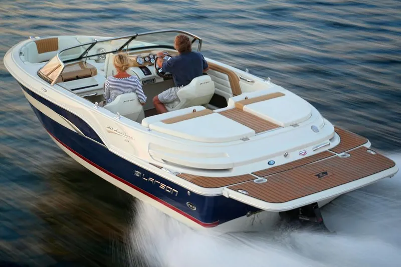Slide: The Image of 2014 Larson All American 23 boat with blue hull and canopy in a garage. - 2