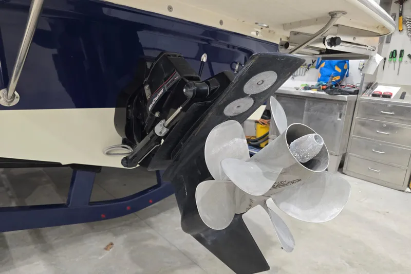 Slide: The Image of 2014 Larson All American 23 boat with MerCruiser propeller in a workshop setting. - 20