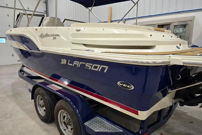 Slide: The Image of 2014 Larson All American 23 boat on trailer in indoor storage. - 21