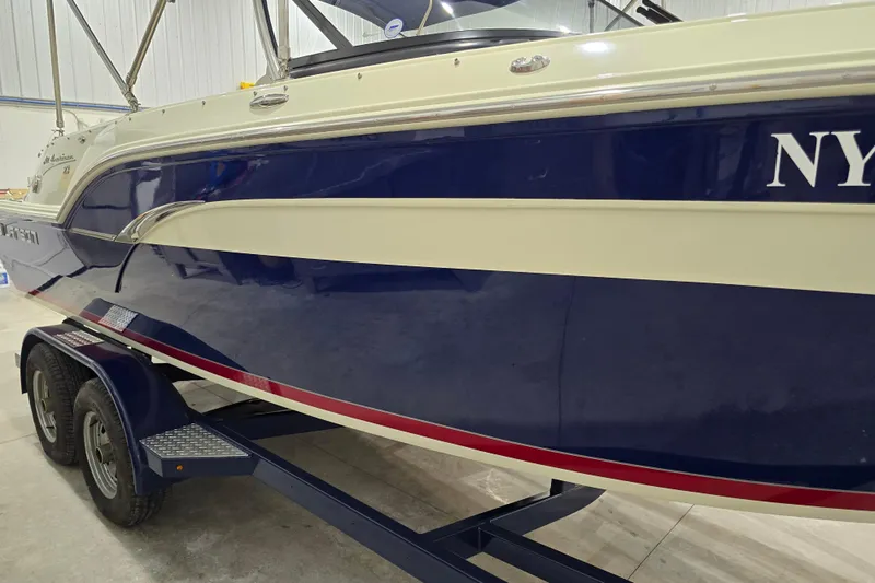 Slide: The Image of 2014 Larson All American 23 boat on trailer in indoor storage. - 22