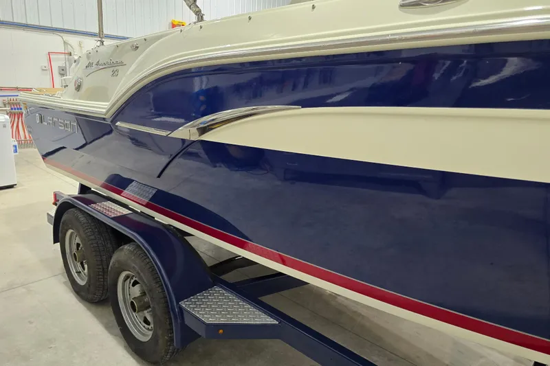 Slide: The Image of 2014 Larson All American 23 boat on trailer in indoor storage. - 23