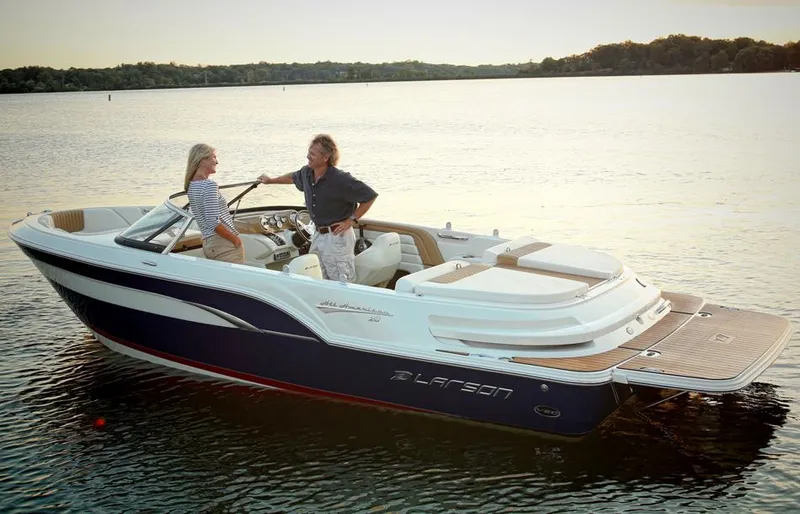 Slide: The Image of 2014 Larson All American 23 boat with blue and cream exterior on a trailer in a garage. - 4