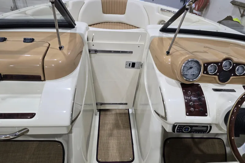 Slide: The Image of Interior of a 2014 Larson All American 23 boat, featuring tan and white dashboard. - 42