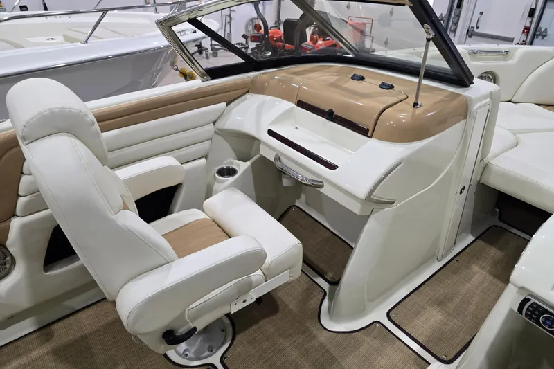 Slide: The Image of 2014 Larson All American 23 boat interior with white seating and beige dashboard. - 48