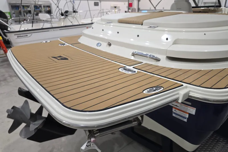 Slide: The Image of 2014 Larson All American 23 boat with teak deck, displayed indoors. - 52