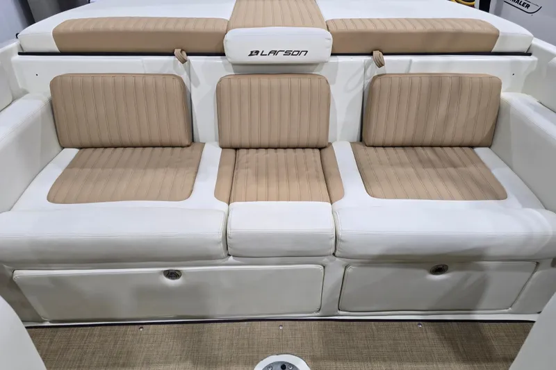 Slide: The Image of 2014 Larson All American 23 boat interior with beige and white cushioned seating. - 57