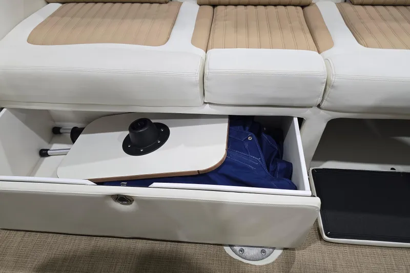 Slide: The Image of 2014 Larson All American 23 boat seat storage with table and blue fabric inside. - 60