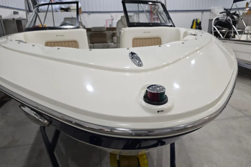 Slide: The Image of 2014 Larson All American 23 boat in a showroom, showcasing sleek design and seating. - 63