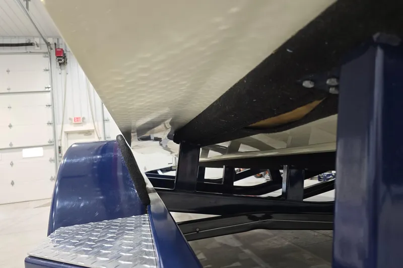 Slide: The Image of 2014 Larson All American 23 boat on trailer in garage setting. - 68