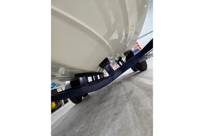 Slide: The Image of 2014 Larson All American 23 boat on trailer, viewed from below in a garage setting. - 69