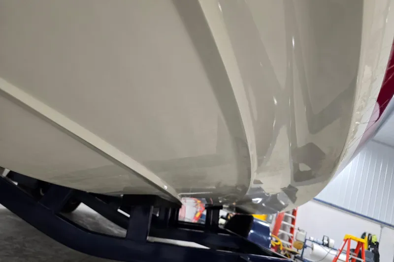 Slide: The Image of 2014 Larson All American 23 boat hull in a workshop setting. - 70