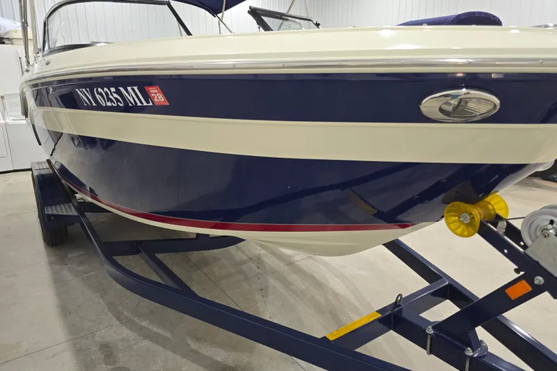 Slide: The Image of 2014 Larson All American 23 boat on trailer, blue and white exterior, indoor storage. - 8