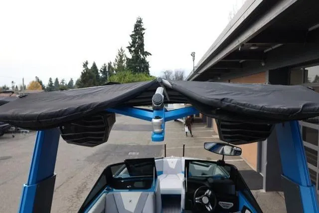 Slide: The Image of 2022 Nautique Super Air Nautique S23 boat with blue tower and black canopy. - 12