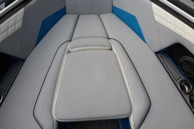 Slide: The Image of 2022 Nautique Super Air Nautique S23 interior with gray and blue cushioned seating. - 24