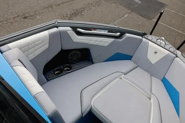 Slide: The Image of Interior of 2022 Nautique Super Air Nautique S23 boat, featuring luxurious seating and cup holders. - 26