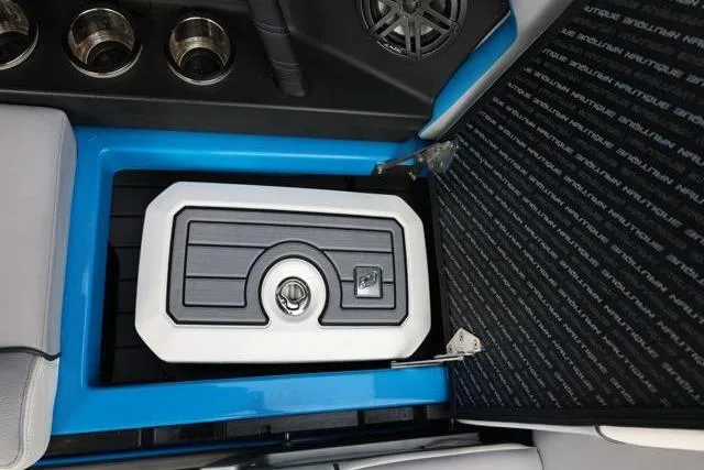 Slide: The Image of 2022 Nautique Super Air Nautique S23 interior storage compartment with cup holders and speaker. - 36
