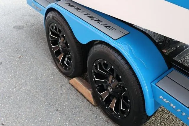 Slide: The Image of 2022 Nautique Super Air Nautique S23 trailer with stylish black wheels. - 58