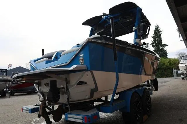 Slide: The Image of 2022 Nautique Super Air Nautique S23 boat, blue and white, on trailer. - 59