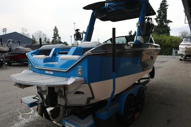 Slide: The Image of 2022 Nautique Super Air Nautique S23 boat, blue and white, parked on a trailer. - 62