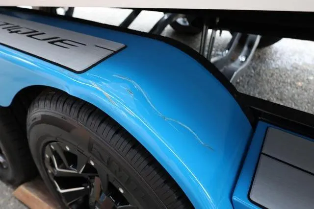 Slide: The Image of 2022 Nautique Super Air Nautique S23 trailer with blue fender and visible scratches. - 8