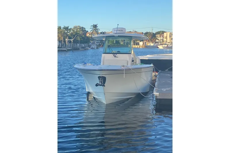 The Image of 2025 Grady-White Canyon 306 boat docked in a marina with palm trees. - 0