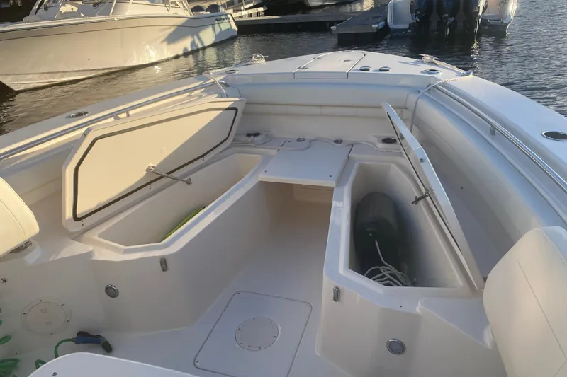 Slide: The Image of 2025 Grady-White Canyon 306 boat interior with seating and storage, docked by the water. - 2