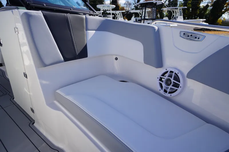 Slide: The Image of 2026 Chaparral 23 SSi OB boat interior with cushioned seating and speaker. - 8