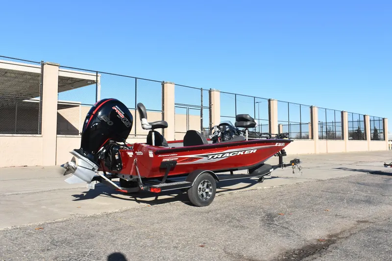 Slide: The Image of 2019 Tracker Pro Team 195 TXW Tournament Edition boat on trailer, parked outdoors. - 2