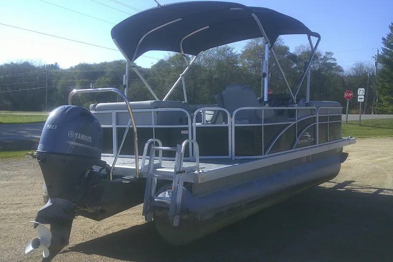 Slide: The Image of 2021 Bennington S 20 L-Bench pontoon boat with Yamaha motor, parked outdoors. - 3