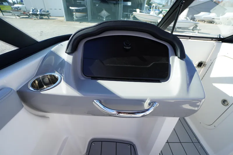 Slide: The Image of 2026 Chaparral 23 SSi OB boat dashboard with cup holder and storage compartment. - 27