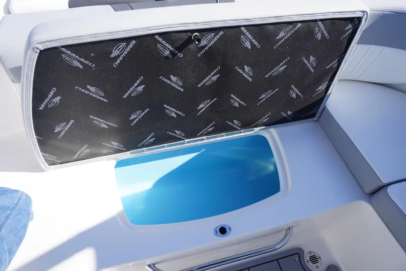 Slide: The Image of 2026 Chaparral 23 SSi OB boat storage compartment with branded cover and blue interior. - 49