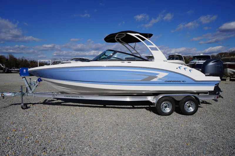 Slide: The Image of 2026 Chaparral 23 SSi OB boat on trailer, blue and white design, parked outdoors. - 70