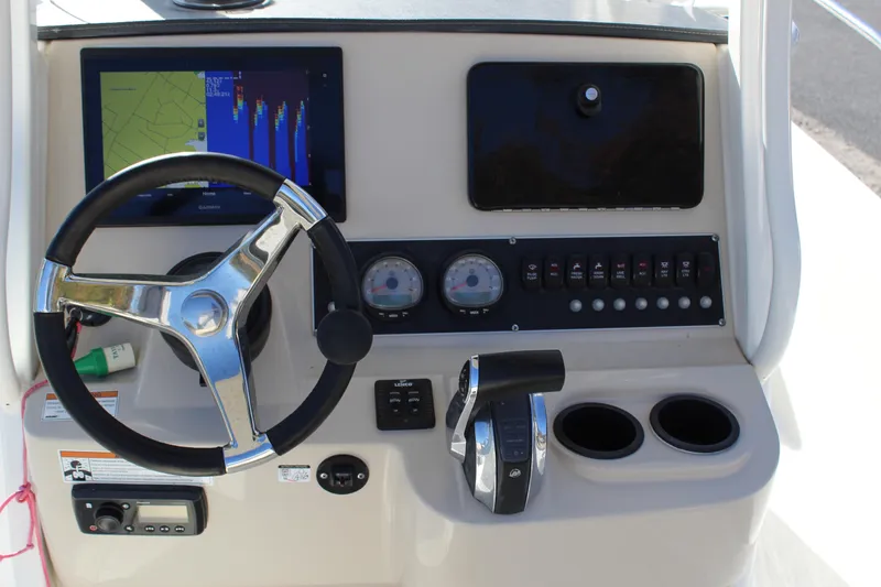 Slide: The Image of 2020 Boston Whaler 240 Dauntless dashboard with steering wheel, controls, and navigation display. - 11