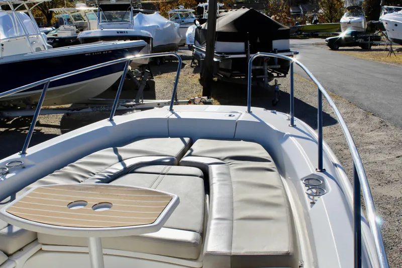 Slide: The Image of 2020 Boston Whaler 240 Dauntless boat with cushioned seating and wooden table. - 14