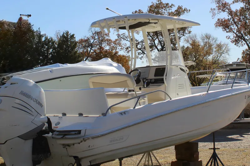 Slide: The Image of 2020 Boston Whaler 240 Dauntless boat with Mercury engine, parked outdoors. - 4