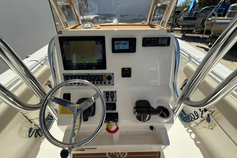 Slide: The Image of 2026 Key West 244 Center Console boat dashboard with steering wheel and navigation controls. - 13