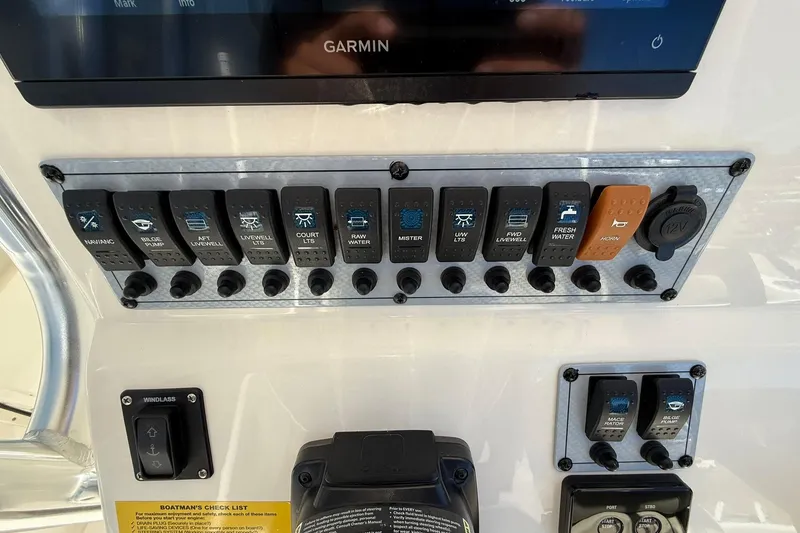 Slide: The Image of 2026 Key West 244 Center Console dashboard with control switches and Garmin display. - 14