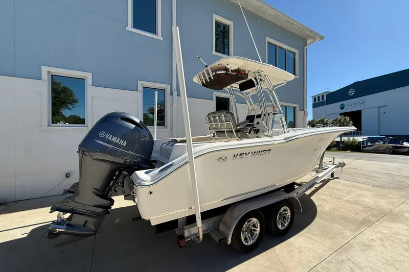 Slide: The Image of 2026 Key West 244 Center Console boat on trailer, parked outside a building. - 4