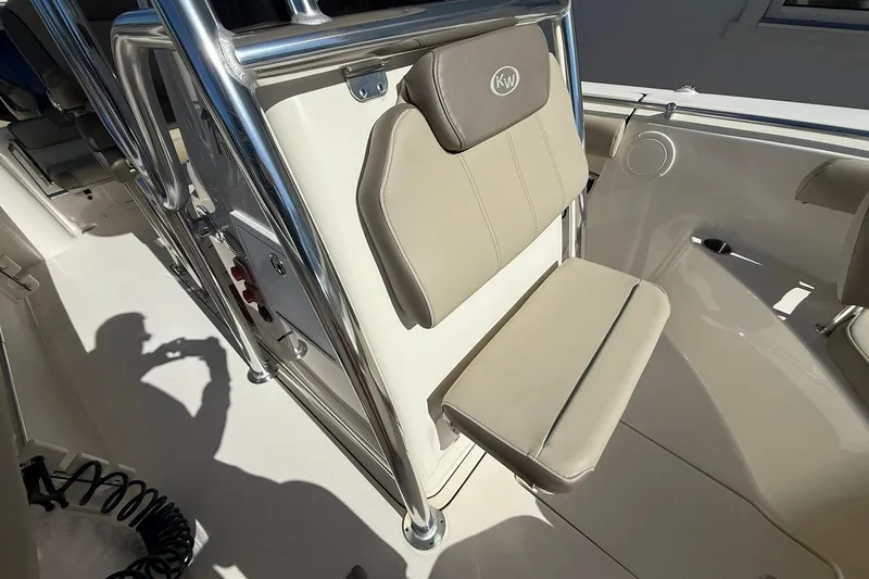 Slide: The Image of 2026 Key West 244 Center Console boat seat with beige upholstery and stainless steel frame. - 6