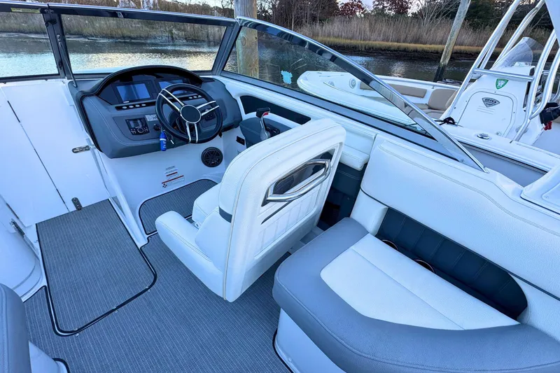 Slide: The Image of 2019 Cobalt 25SC boat interior with steering wheel and seating area. - 13