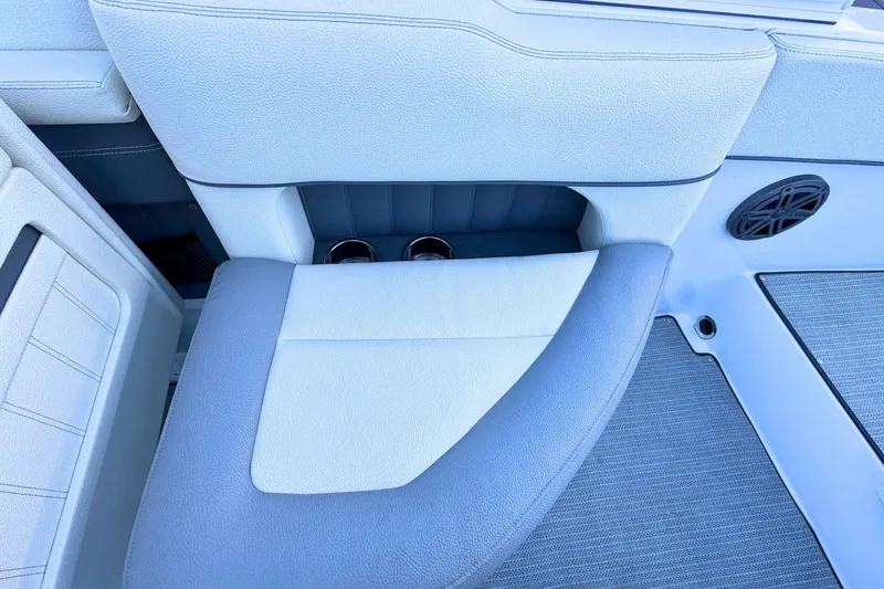 Slide: The Image of 2019 Cobalt 25SC boat interior with white and gray seating, cup holders, and speaker. - 14