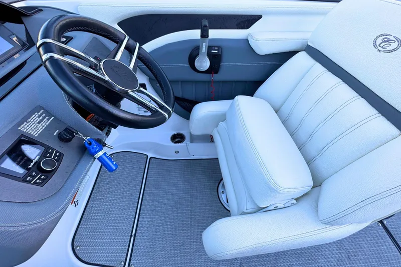 Slide: The Image of 2019 Cobalt 25SC boat interior with steering wheel and white captain's chair. - 17