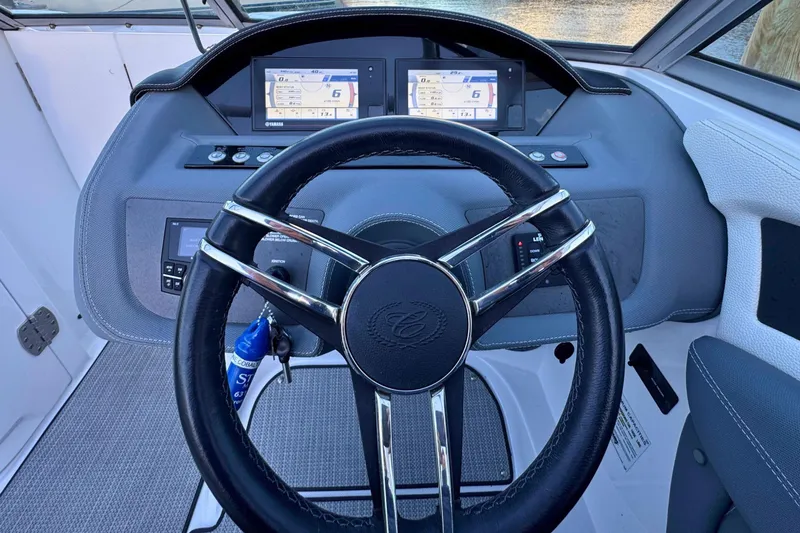 Slide: The Image of Steering wheel and dashboard of 2019 Cobalt 25SC boat, featuring digital displays. - 21