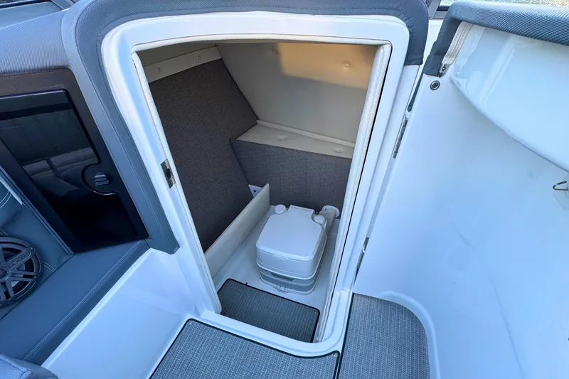Slide: The Image of 2019 Cobalt 25SC boat interior with compact marine toilet. - 24