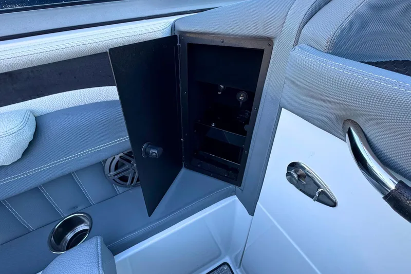 Slide: The Image of 2019 Cobalt 25SC boat interior with open storage compartment and speaker. - 25