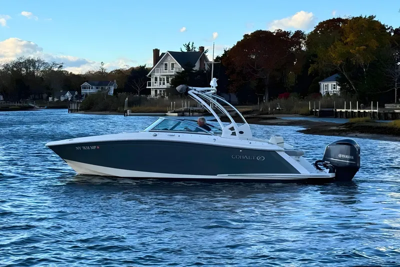 Slide: The Image of 2019 Cobalt 25SC boat cruising on a scenic waterway with houses in the background. - 3