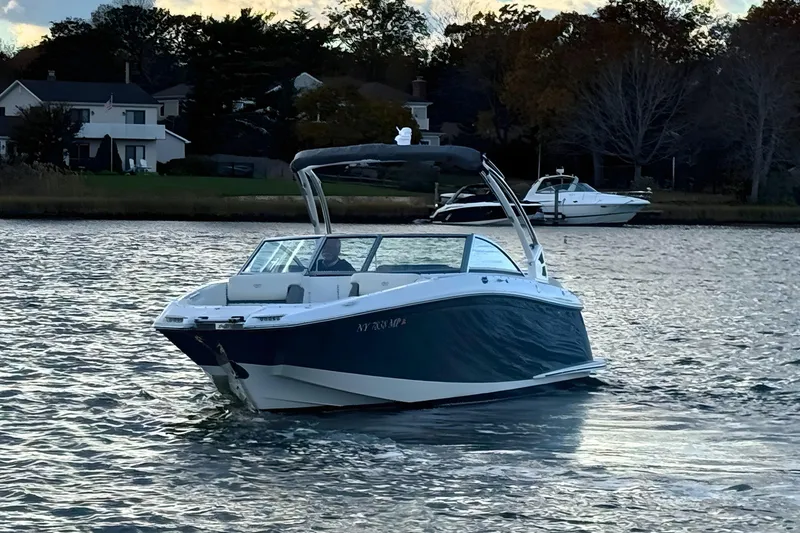 Slide: The Image of 2019 Cobalt 25SC boat cruising on a scenic waterway near houses. - 8
