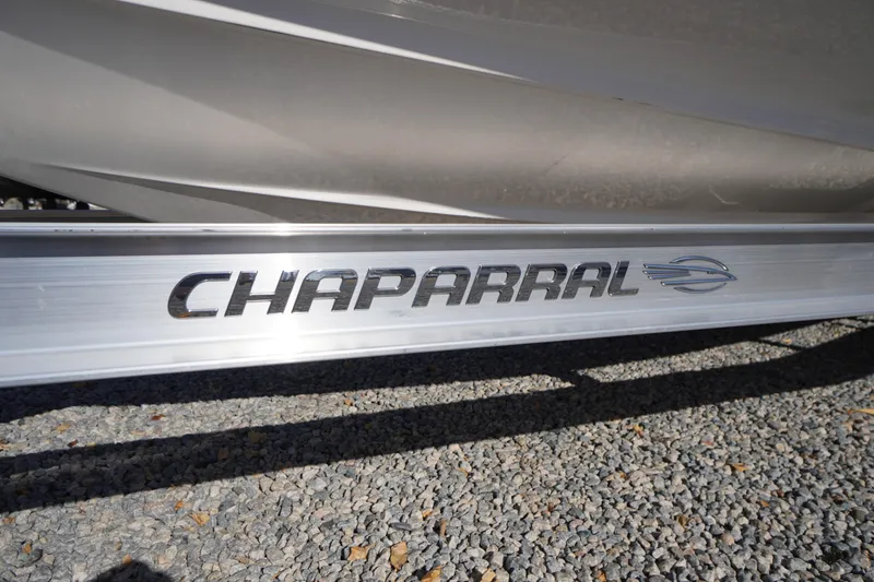Slide: The Image of 2026 Chaparral 23 SSi OB boat logo on metallic surface, gravel background. - 67