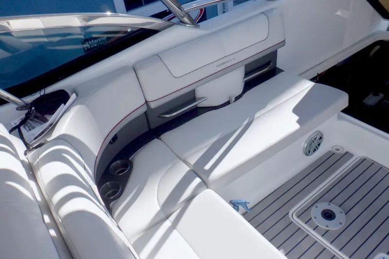 Slide: The Image of 2015 Formula 350 Crossover Bowrider boat with red and white design docked outdoors. - 6