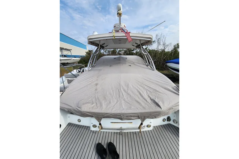 Slide: The Image of 2015 Formula 350 Crossover Bowrider covered, docked with American flag, clear sky background. - 65